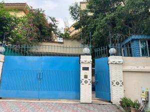 a blue gate in front of a house at Arizona Lodge Guesthouse in Islamabad