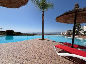 una piscina con dos sillas y una palmera en Cabo Dream - Cabo, en Cabo Negro