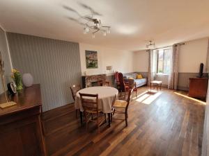 a dining room with a table and chairs and a living room at Aux Galets de Gisou in Ahun
