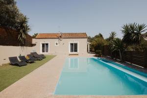 a swimming pool in the backyard of a house at Villa Eros in Vátos