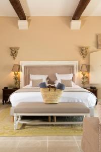 ein Schlafzimmer mit einem weißen Bett, auf dem ein Korb steht in der Unterkunft Le Phébus & Spa – Relais & Châteaux in Joucas + 108 Fotos