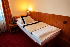 乌赫尔堡格兰德酒店的房间里有一张带木质床头板的床