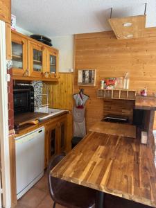 a kitchen with wooden cabinets and a wooden table at Studio station Puy-Saint-Vincent in Puy-Saint-Vincent