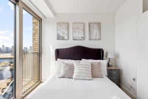 a bedroom with a white bed with a large window at TM luxury apartments in London