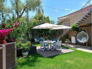 a patio with a table and chairs and an umbrella at Studios Katerina in Nydri