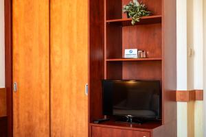 乌赫尔堡格兰德酒店的书架上的电视,带电视