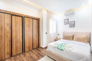 a bedroom with a large bed and a wooden closet at Cocoon in Gueliz, Netflix, IPTV in Marrakech