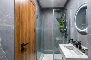 a bathroom with a shower and a sink and a wooden door at Cocoon in Gueliz, Netflix, IPTV in Marrakech