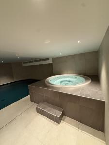 Les ChavantsThe Bear - Sauna Piscine - Face au Kandahar的带游泳池的客房内的热水浴池