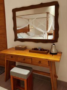 a dressing table with a mirror and a bed at Terrace Retreat & Spa Medewi in Pulukan