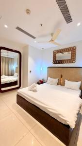 グルガオンにあるHigh Rise Royal Luxury 2 BHK with Private Patioの大きなベッドと鏡のある寝室