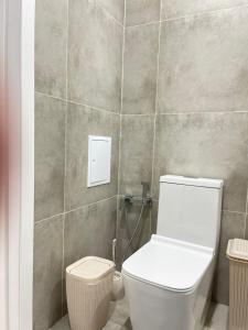 ein Bad mit einem WC und einer Fliesenwand in der Unterkunft Двухкомнатная квартира in Astana + 2 Fotos