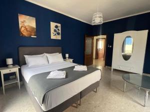 a bedroom with a large bed and a blue wall at Spacious house with roof-terrace in Mellieħa