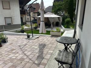 a patio with a table and an umbrella at APARTMA ALMA in Bovec