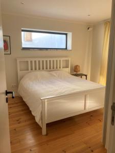 a white bed in a bedroom with a window at Casa Sol e Mar - Family stays in Torres Vedras