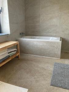 a bathroom with a tub and a tile floor at Casa Sol e Mar - Family stays in Torres Vedras +25 photos