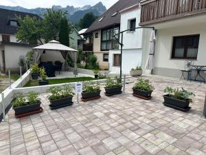 a patio with a bunch of potted plants on it at APARTMA ALMA in Bovec
