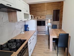 a kitchen with white cabinets and a table with a stove at Apartments Margareta in Novigrad Istria