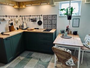 a kitchen with green cabinets and a wooden table at Minicottage Casa de Lipa in Kostanjevica na Krki