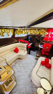 Un salón de fiestas con sofás y un cartel de feliz aniversario. en El Mundo Baby, en Sabkhah 2 fotos más