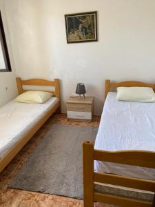 a bedroom with two beds and a night stand with a lamp at Bigova Peace Oasis in Bigovo