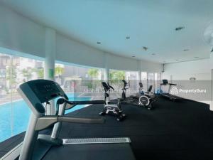 安邦Cozy 2BR Apt AxisAtrium Mall wPool Pandan Indah Ampang Kuala Lumpur的带有氧器材的健身房,位于带游泳池的大楼内