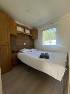 Un dormitorio con una cama con dos zapatos negros encima. en Domek z widokiem na jezioro, en Jora Wielka 22 fotos más