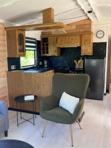 Una cocina con una silla verde y una mesa. en Domek z widokiem na jezioro, en Jora Wielka