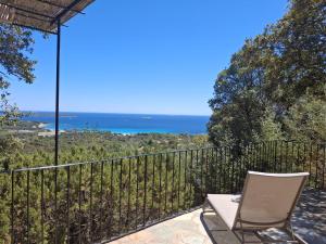 a patio with a chair and a view of the ocean at Résidence Belvedere de Palombaggia in Porto-Vecchio