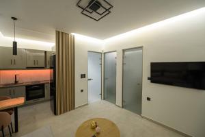 a kitchen with a table and a tv on a wall at Modern house Katoikia Pyrgos in Pyrgos