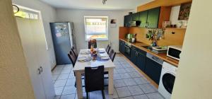 a small kitchen with a table and a refrigerator at Haus Karle in Ettenheim