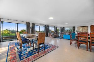 a dining room with a table and chairs and a living room at Beach Galore - Waihi Beach Holiday Home in Waihi Beach