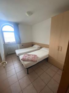 a small room with two beds and a window at Casa Mara - Agriturismo Fantelli Luciano in Dimaro