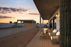 a deck with couches and chairs on a building at Villa Solace by Fieldtrip Modern Desert Oasis w Pool in Joshua Tree