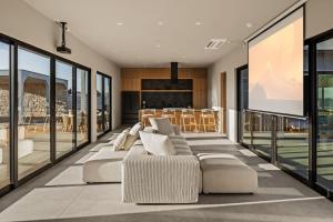 a living room with white furniture and a projection screen at Villa Solace by Fieldtrip Modern Desert Oasis w Pool in Joshua Tree