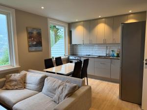 a living room with a couch and a table and a kitchen at Modern apartment with free parking in Bergen