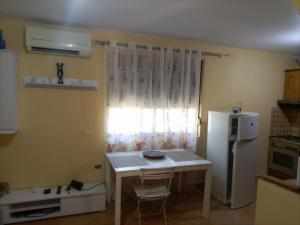 a small kitchen with a small table and a refrigerator at Salis Home in Polisi i Vogël