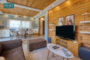 a living room with a television and a dining room at Prime Holidays Mountain View Ras ElHekma in Ras Elhekma