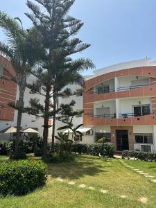 un edificio con una palmera delante en Résidence Oubaha - Grand appartement avec piscine, en Mohammedia 11 fotos más