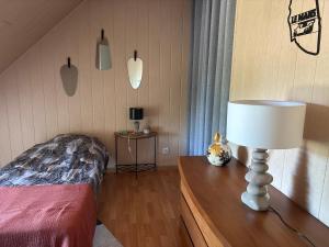 a bedroom with a bed and a lamp on a table at Chambre proche circuit in Spay