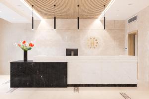 a lobby with a reception desk with flowers at Helnan Antoniades Palace Hotel in Alexandria +51 photos