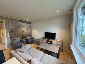 a living room with a couch and a tv at Modern apartment with free parking in Bergen