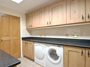 a laundry room with a washing machine in it at Magnolia Cottage in Aberaeron +11 photos