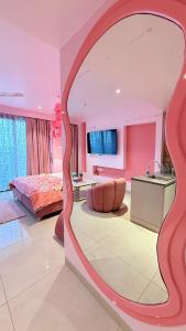 a bedroom with a large mirror in a room at LuxePink Teddd Jucuzzi Studio-PrivatePatio in Gurgaon +35 photos