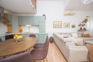 a kitchen and living room with a table and a couch at Villa Mediteran - Beach Villa with Jacuzzi in Vir