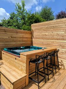 a wooden deck with a hot tub and two chairs at Tor zum Saueland mit Sauna und Whirlpool in Olpe