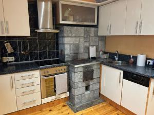 a kitchen with white cabinets and black counter tops at Pharaoh Apartment in Balvi