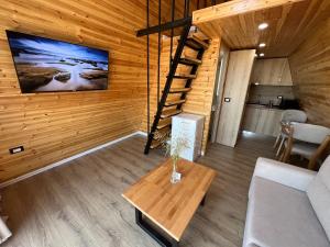 a living room with a staircase in a log cabin at Doel House Zues - Hot Tub Villa & Scenic View in Shkodër