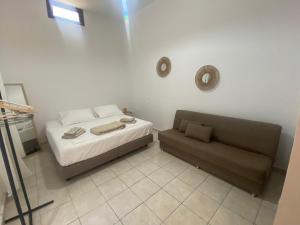 a small bedroom with a bed and a couch at Isola Studio 1 in Rhodes Town