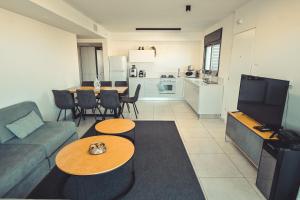 uma sala de estar com um sofá e mesas e uma cozinha em Magdala Resort 2BR With private pool em Migdal